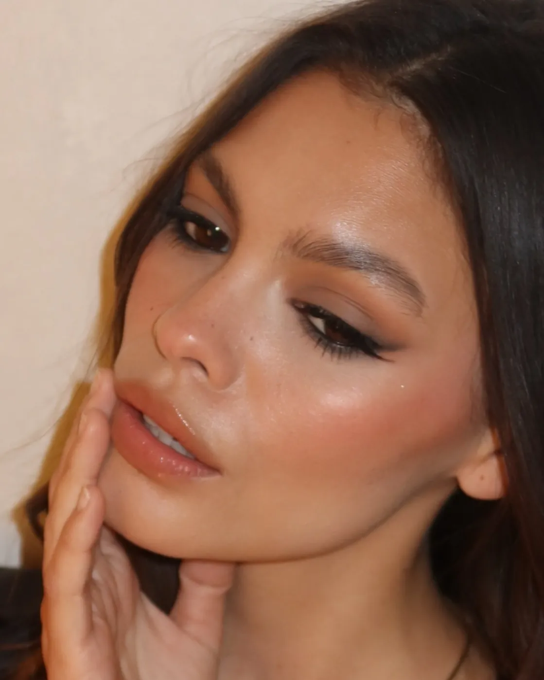 Side glance with winged liner and flushed skin
