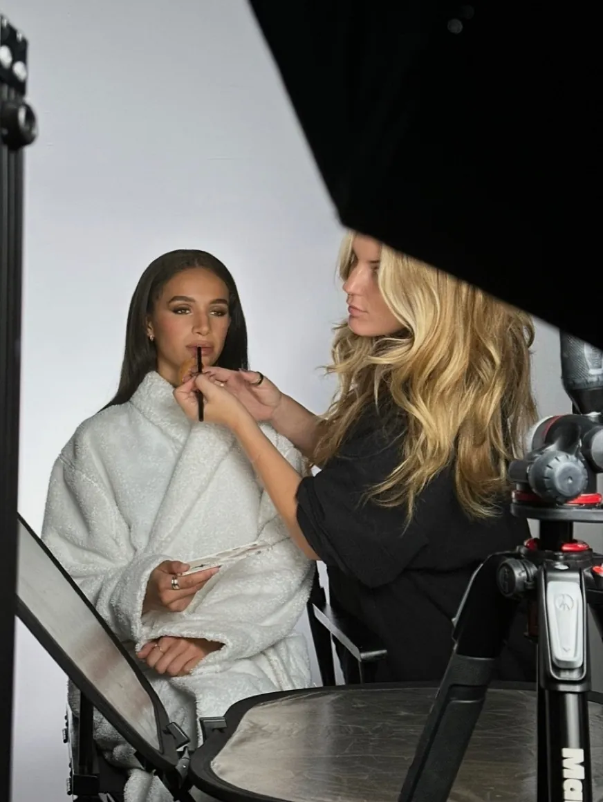 Zoë Elizabeth applying lip colour to a model on set