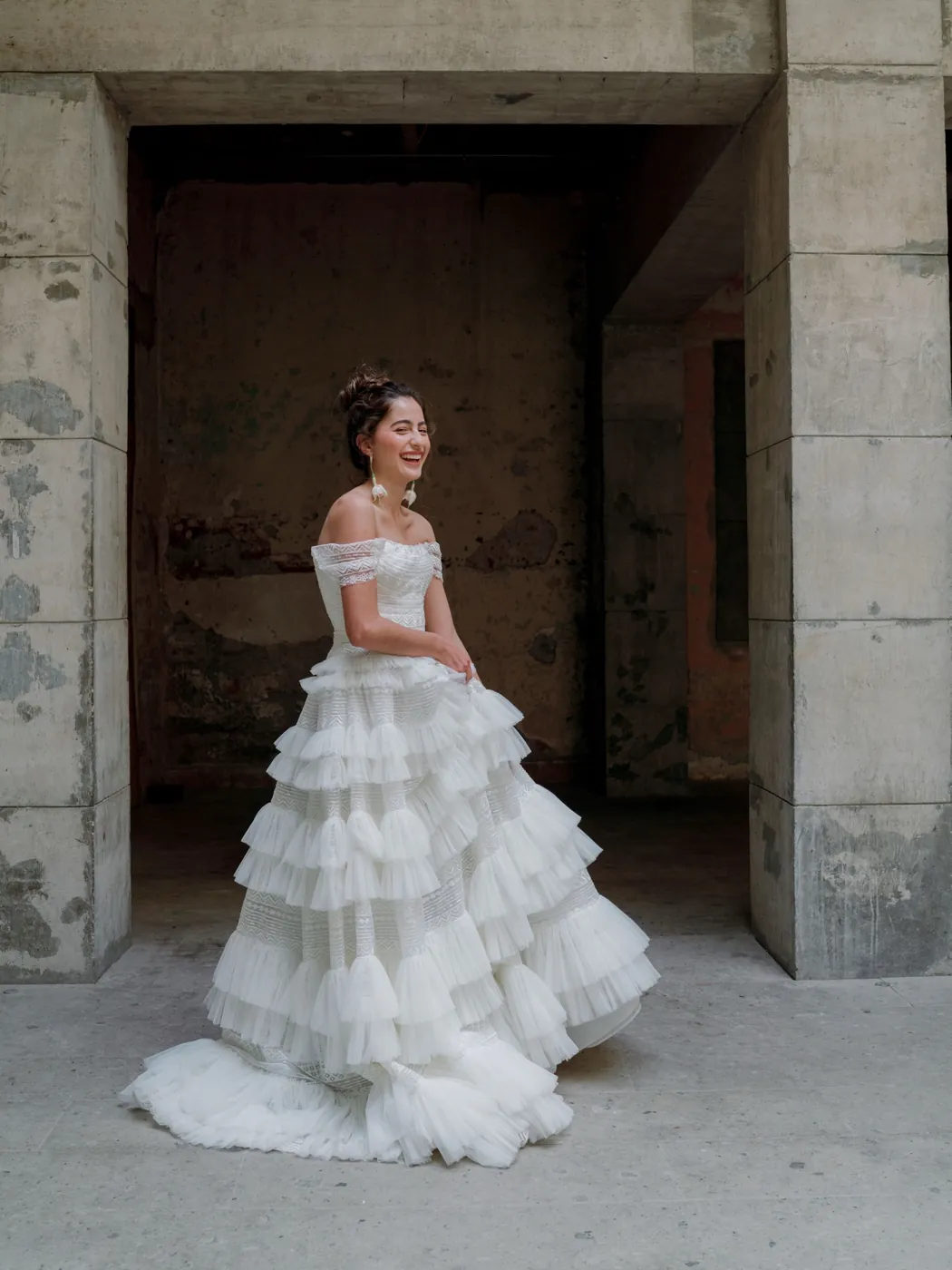 Bride in a tiered gown in a stone archway