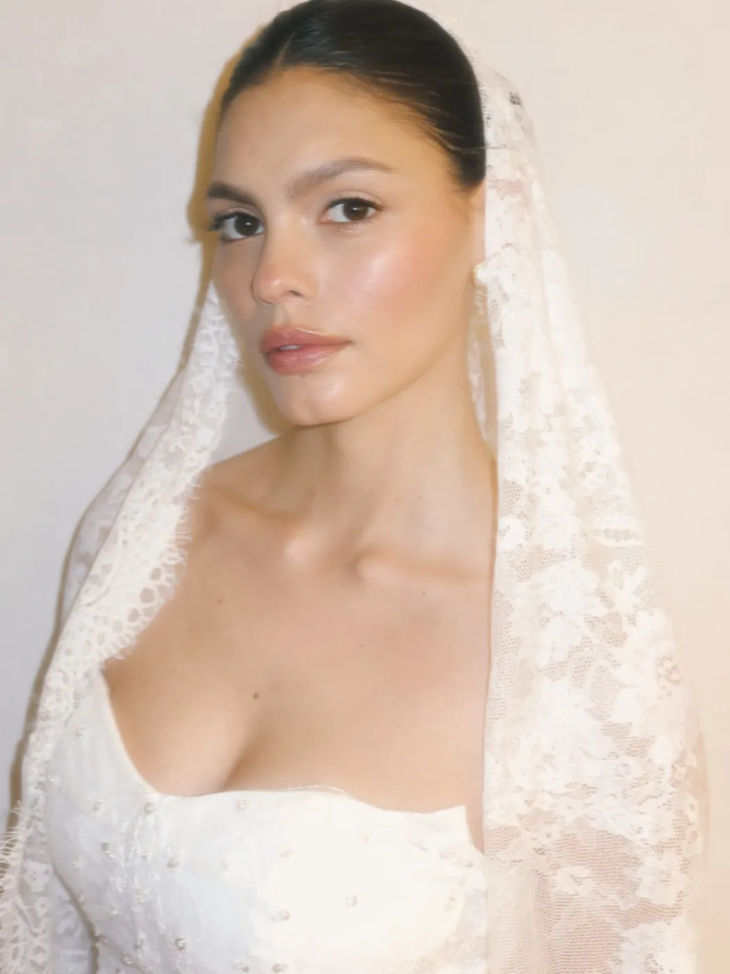 Bride in a lace veil with luminous skin