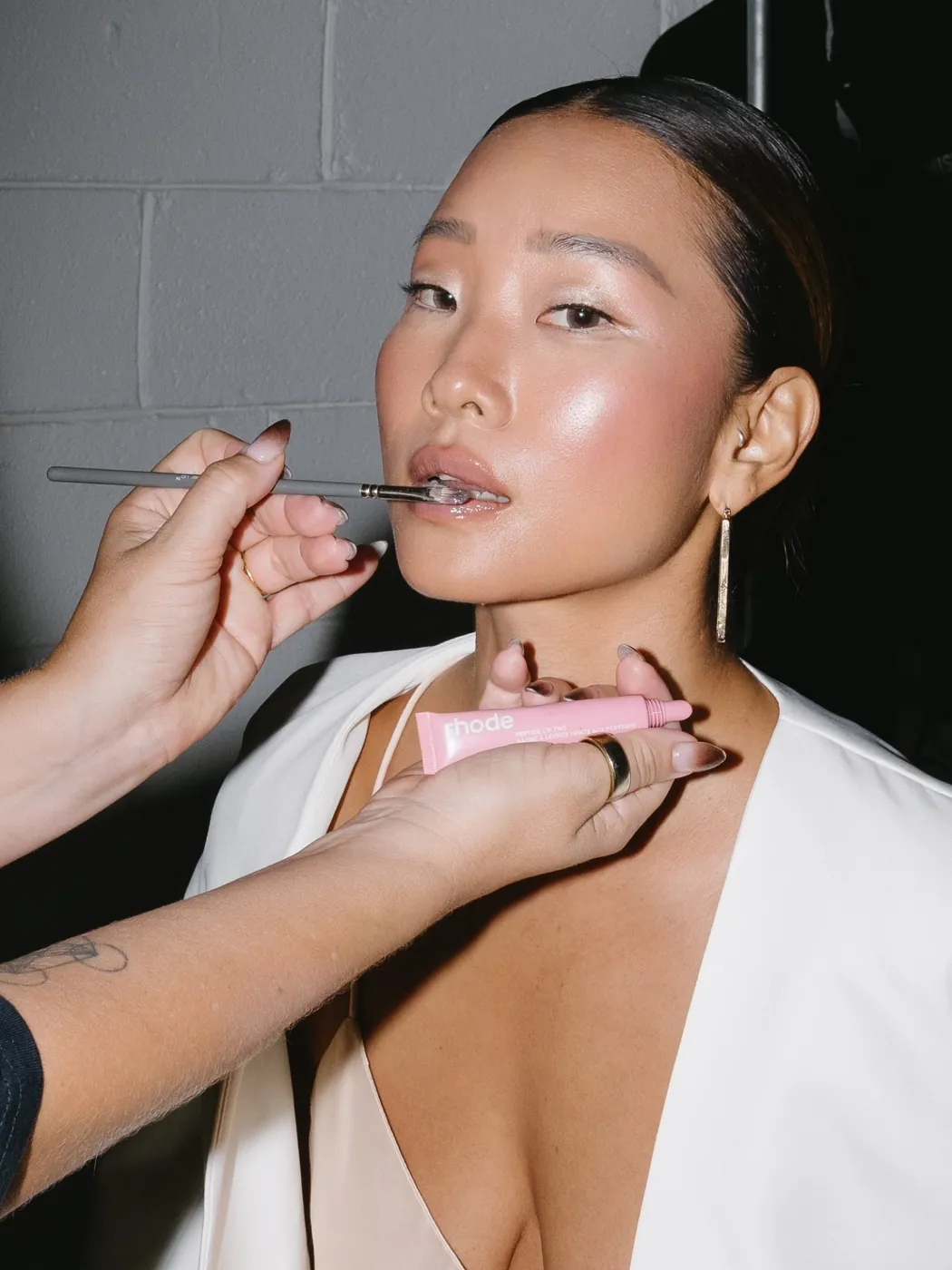 Zoë Elizabeth applying lip colour to a model with a sleek bun