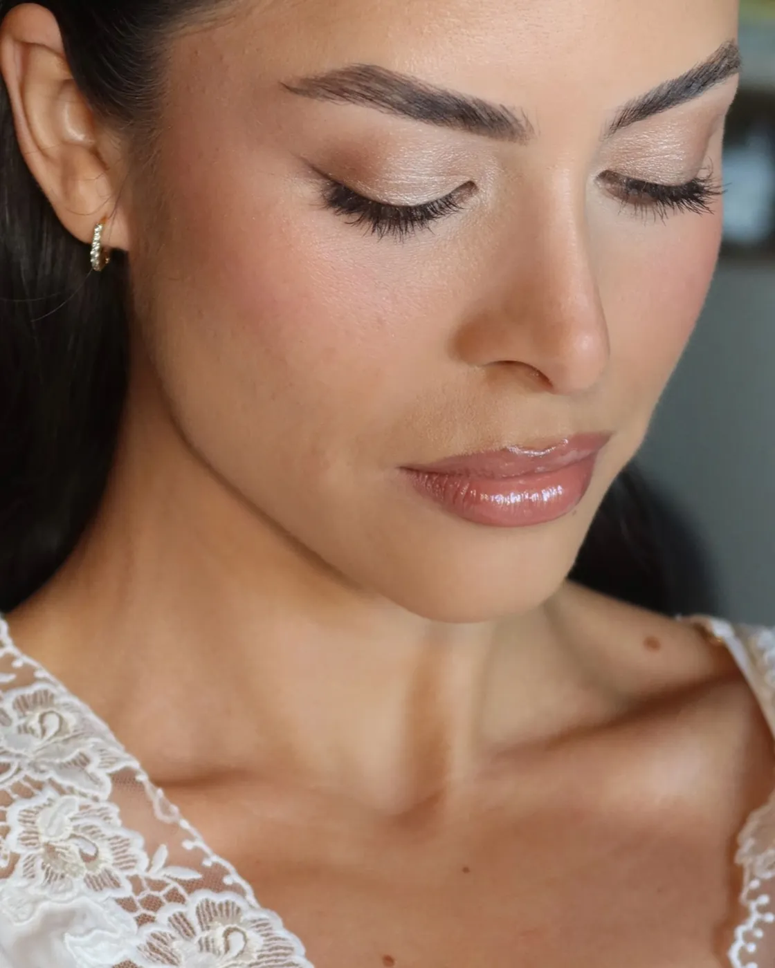Bride in a lace robe with a soft bronze lid and glowing skin